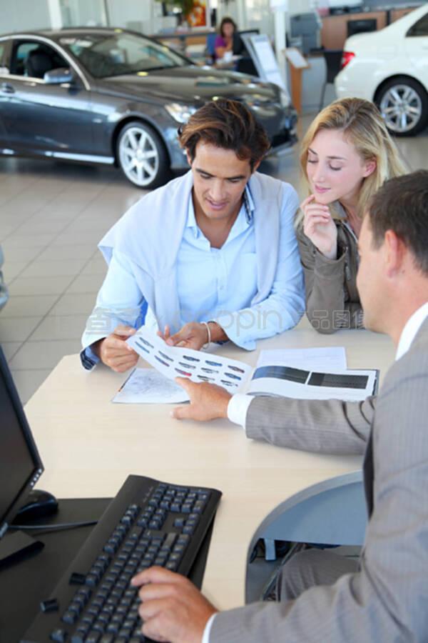 汽车销售商和夫妇看目录